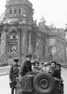 Илья Аронс, Генерал-майор Матвей Вайнтруб, писатель Константин Симонов, кинооператор Илья Аронс (справа-налево) у здания Рейхстага, Берлин, 1945 год.